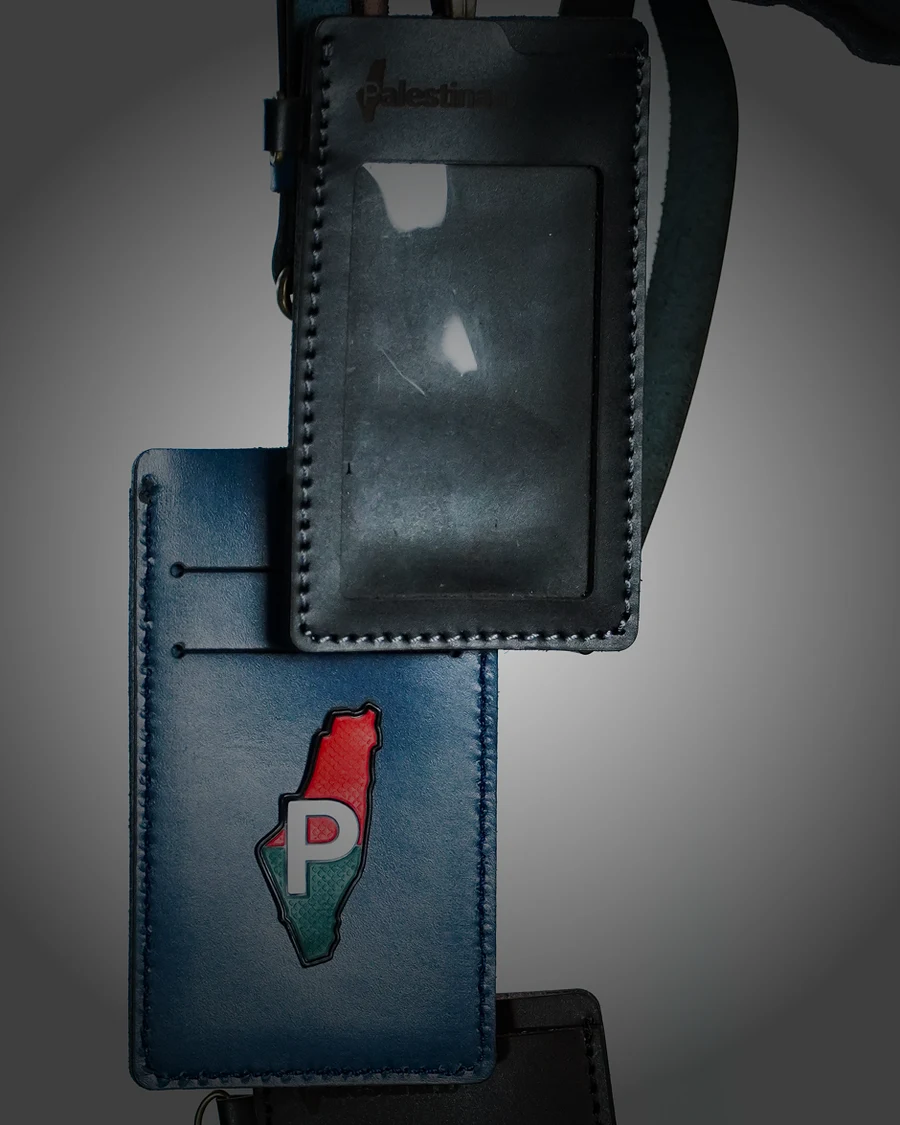 The Palestine map crest pressed into a navy leather card holder