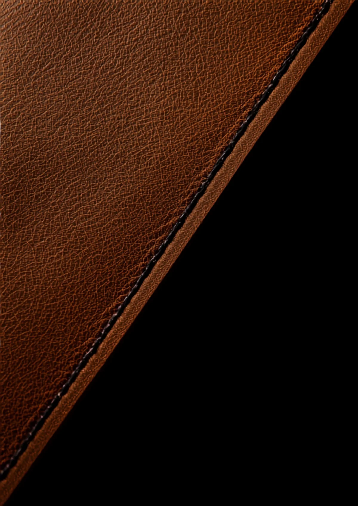 Macro detail of vegetable-tanned leather with a saddle stitch running through raking light